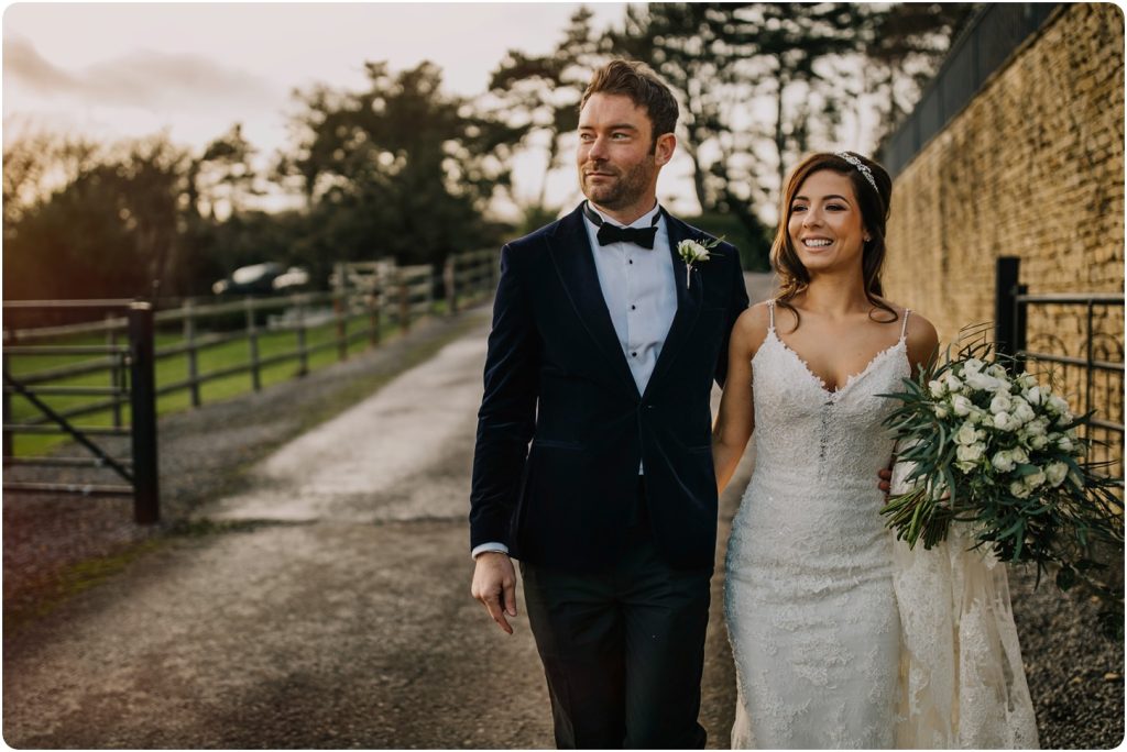 bride and groom walking at a kingscote barn wedding