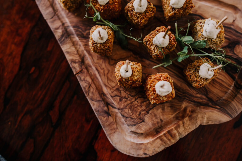 Close-up of wedding canapés served on a wooden board during drinks reception at Elmore Court.
