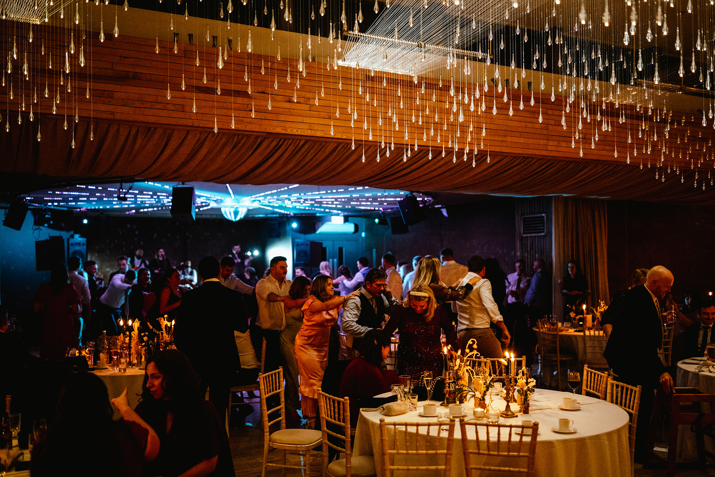 Evening wedding party inside the Gillyflower at Elmore Court with guests dancing and celebrating
