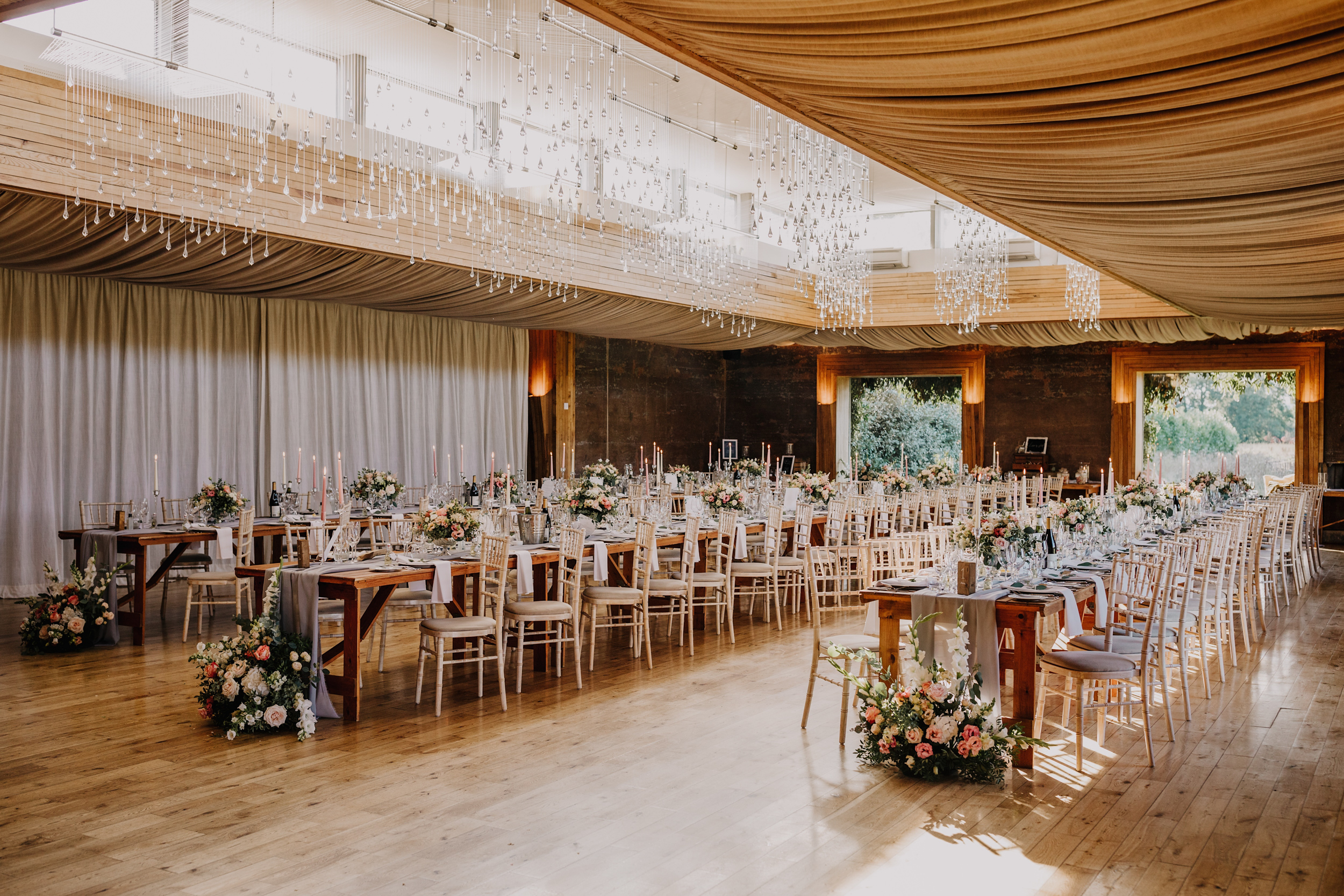 The Gillyflower set up for a wedding breakfast with long tables and flowers and candles shot by an Elmore Court wedding photographer