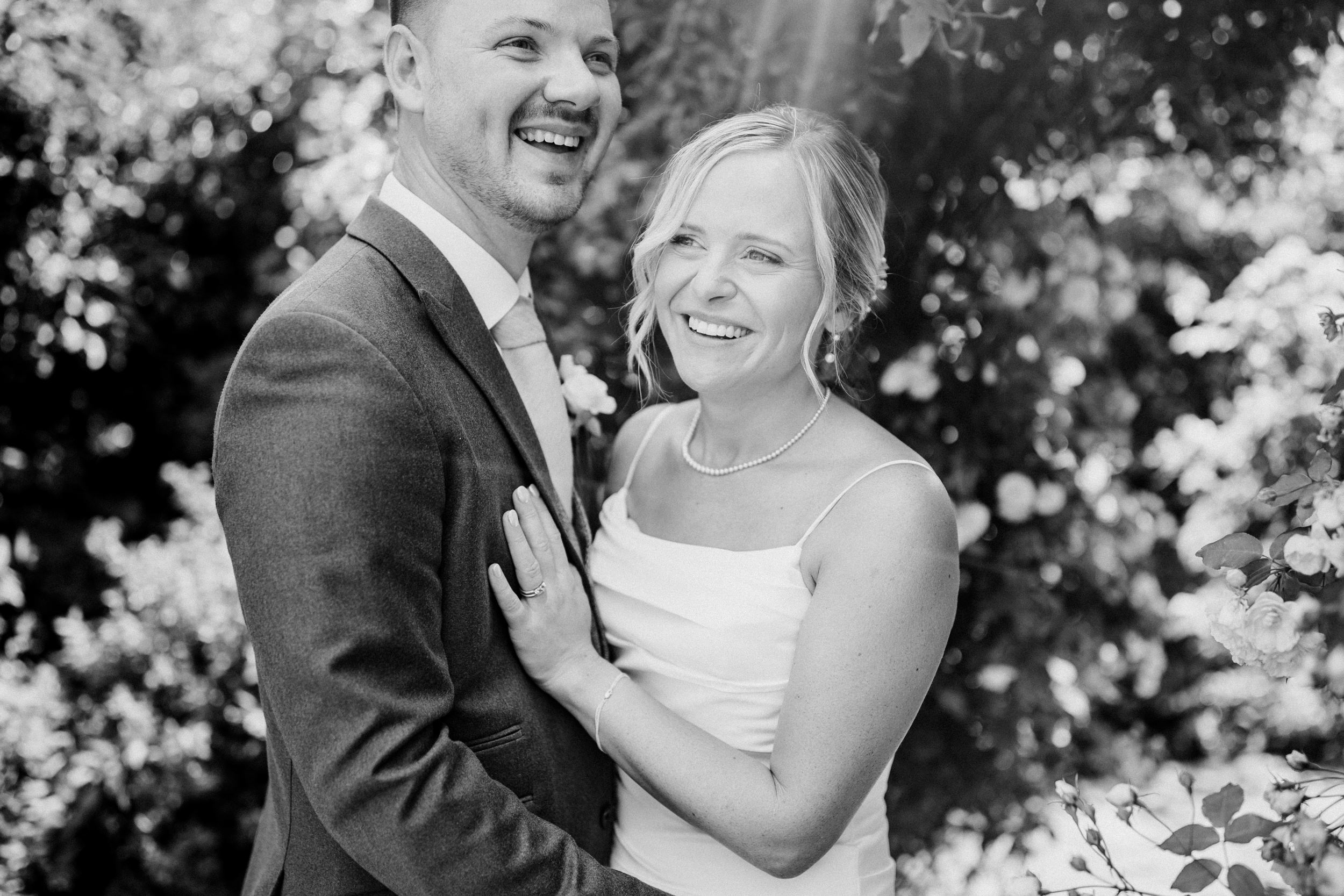 relaxed wedding photo of a couple at Kingscote barn laughing together
